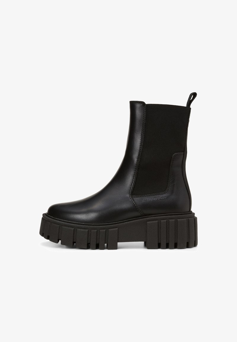 Botte Chelsea mi-mollet en cuir noir avec semelle épaisse à rainures, panneaux latéraux élastiques et boucle à l'arrière.