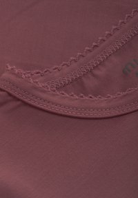 T-shirt di colore rosa antico con una texture liscia, caratterizzato da un collo a scallop e un logo discreto stampato vicino al collo.