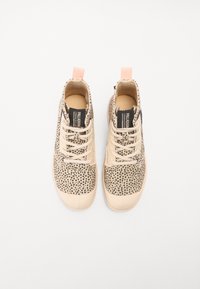 Zapatillas de plataforma beige con un patrón de manchas, diseño de cordones, punta redondeada y etiqueta de tira rosa. Presentan una superficie texturizada y una lengüeta etiquetada.