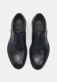Scarpe in pelle blu scuro con finitura liscia, design con lacci, punta tondeggiante e solette testurizzate. Suole in gomma con dettagli discreti.