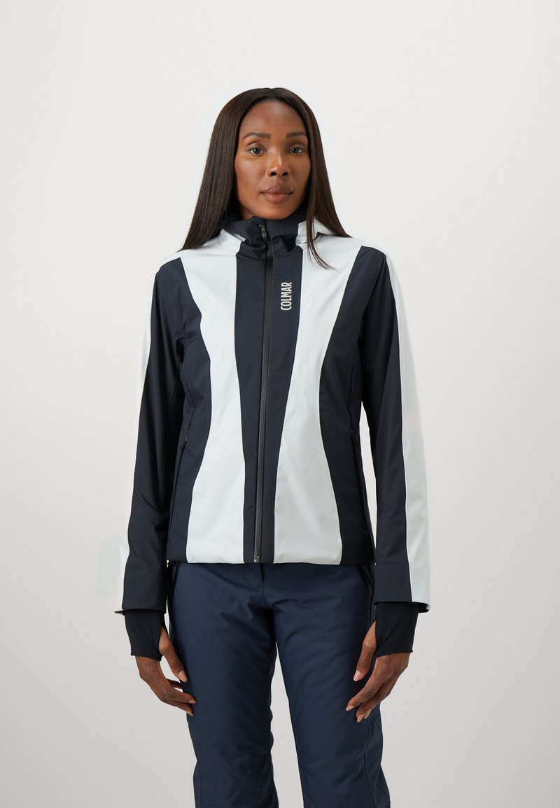 Schwarze und weiße Jacke mit hohem Kragen, Reißverschluss vorne und Daumengriffen. Glattes, wasserabweisendes Material mit kontrastierenden vertikalen Streifen.