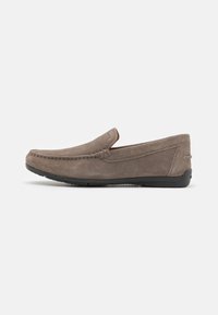 Mocasines de ante gris con una textura suave, punta redonda y detalles de costura a lo largo de la parte superior. Suela de goma para mayor agarre y flexibilidad.