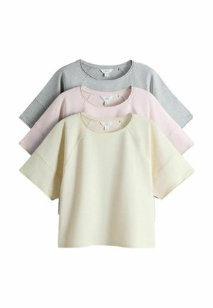Tre kortærmede crewneck-sweatshirts stakket oven på hinanden i farverne creme, lyserød og lysegrå, vist på hvid baggrund.