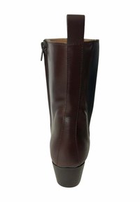 Botín de cuero marrón con un diseño elegante, cremallera lateral y tacón corto. Presenta una textura suave y una forma cónica.