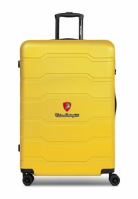 Maleta amarilla de material rígido con superficie texturizada, logo distintivo y ruedas negras. Cuenta con un asa retráctil y un diseño moldeado.