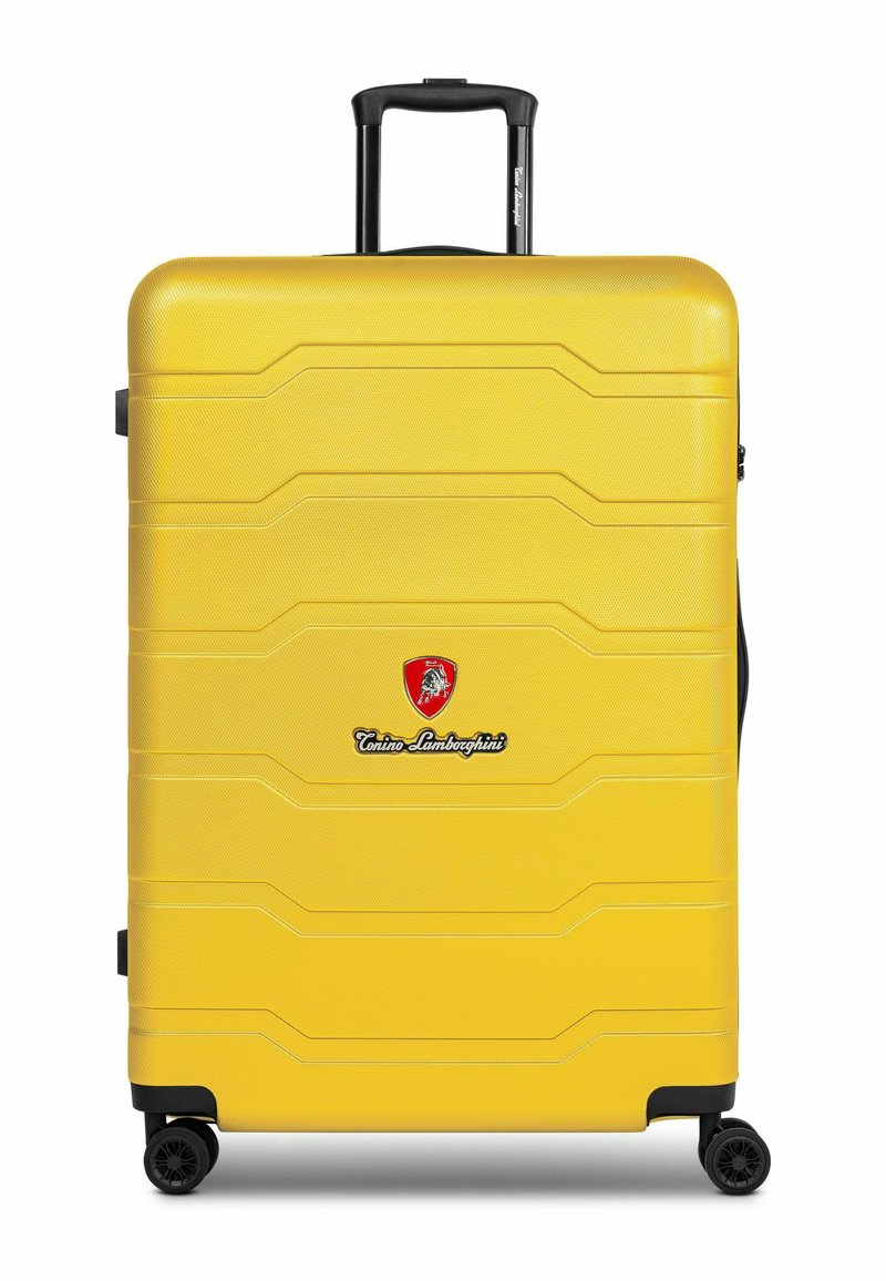 Maleta amarilla de material rígido con superficie texturizada, logo distintivo y ruedas negras. Cuenta con un asa retráctil y un diseño moldeado.