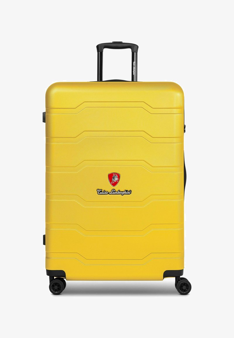 Maleta amarilla de material rígido con superficie texturizada, logo distintivo y ruedas negras. Cuenta con un asa retráctil y un diseño moldeado.