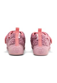 Chaussons en peluche rose avec un dessus texturé, une doublure douce et une languette à l'arrière. Comportent des semelles en caoutchouc et un logo estampé en dessous.