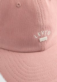Pink corduroy cap with a curved brim and embroidered white "Levi's" logo on the front. Features subtle vertical ribbing texture.