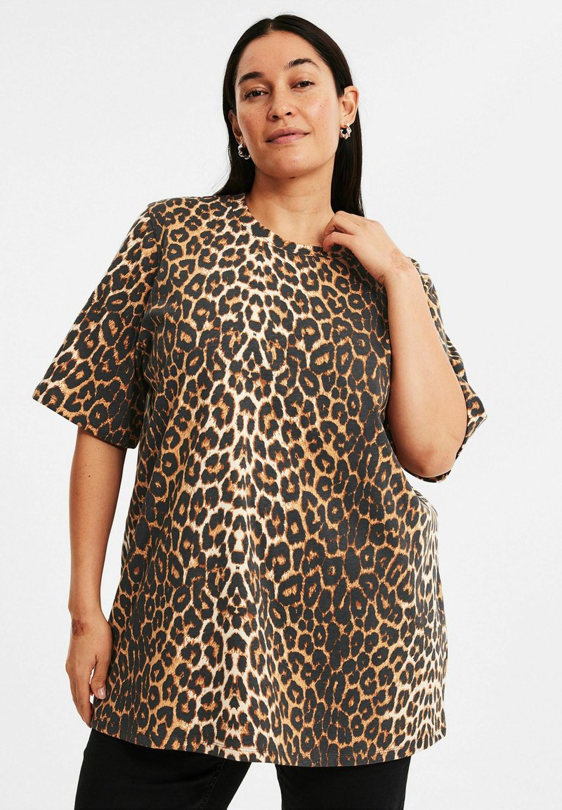 Leopardmönstrad T-shirt, kortärmad, rund halsringning, lös passform, gjord av mjukt tyg med svarta, bruna och tanfärgade mönster.