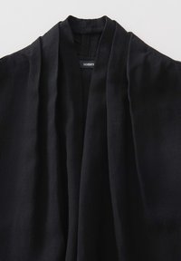 Kimono noir léger fait de tissu doux, avec un décolleté en V profond, des manches amples et un design drapé avec une texture subtile.