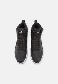 Zapatillas altas negras con parte superior de cuero suave, puntera perforada, cordones negros, cuello acolchado y suela de goma blanca.