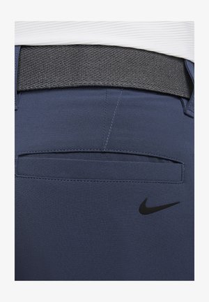 Pantalones deportivos azul marino con una cinturilla texturizada en gris, con un bolsillo en la parte trasera y un logo de Nike negro en el lado inferior.