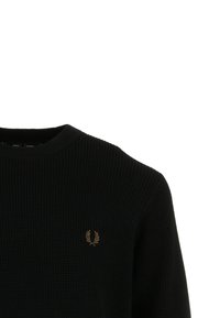 Schwarzer, gerippter Pullover mit Rundhalsausschnitt. Merkmale ein kleines, goldenes Lorbeer-Logo auf der linken Brust. Texturiertes Material und lockere Passform.