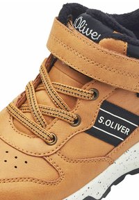 Braune Leder-High-Top-Sneaker mit schwarzen Akzenten, auffälligen Schnürsenkeln und einem markierten Riemen. Texturiertes Obermaterial mit Perforationen und gesprenkelter Sohle.