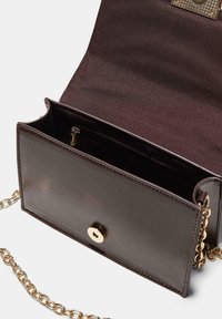 Dunkelbraune Lederhandtasche mit goldener Hardware, ausgestattet mit einer Ketten-Tragriemen, einem Klappenverschluss und einem inneren Reißverschlussfach für Stauraum.