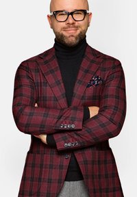 Burgundowa marynarka w kratę z czarnymi akcentami, z dopasowanym krojem, kontrastującym czarnym golfem i wzorzystą poszetką.