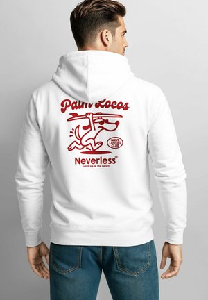 Mann trägt einen weißen Kapuzenpullover mit rotem Grafikdesign eines Hundes, der ein Surfbrett trägt, sowie dem Text "Palm Locos", "Neverless" und "Wave Lovers Club" auf dem Rücken.