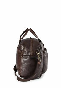 Sac de voyage en cuir marron avec fermeture éclair, deux poignées supérieures, bandoulière réglable et détails de couture proéminents.