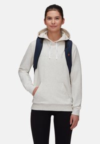 Ljusgrå hoodie med en känguruficka, vita snören och präglad text. Bärs med svarta tights och en mörk ryggsäck.