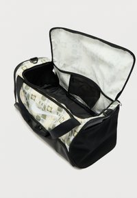 Μαύρη και ανοιχτόχρωμη τσάντα duffel με γεωμετρικό σχέδιο. Διαθέτει φερμουάρ στην κορυφή, εσωτερική τσέπη και ανθεκτικό υλικό ύφασμα.