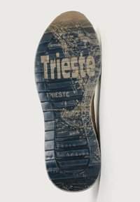 Suola in gomma blu scuro con un design della mappa di Trieste, con lettere in rilievo e un motivo di grip testurizzato.