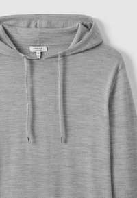 Grauer Kapuzenpullover aus strukturiertem Strickstoff, mit einer Kordelzugkapuze und metallischen Enden. Das angezeigte Etikett ist mit "REISS" in Größe M gekennzeichnet.