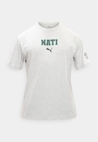 Ανοιχτό γκρι κοντομάνικο T-shirt με τη λέξη "NATI" σε σχέδιο πάνω από το μαύρο λογότυπο Puma και ένα μικρό γραφικό στο δεξί μανίκι.