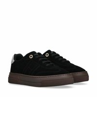 Sneaker in suede nera con suola in gomma marrone spessa, dotate di lacci neri e occhielli argentati. Accentuate da una linguetta posteriore in argento.