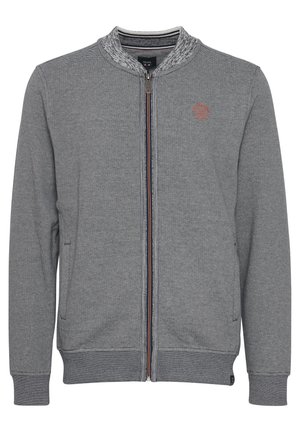 Szürke cipzáras dzseki texturált csíkos mintával, bordázott gallérral, mandzsettával és szegéllyel, kis narancssárga logóval a bal mellrészen.