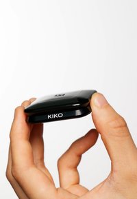 Svart kompakt enhet med rundade kanter och en blänkande yta. Varumärket "KIKO" är tydligt synligt på sidan.