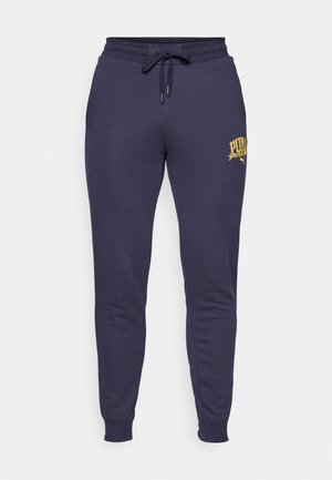 Pantalons de survêtement bleu marine en tissu doux en mélange de coton, avec une taille élastique à cordon de serrage et un détail de logo doré sur la cuisse gauche.