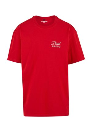 T-shirt en coton rouge à manches courtes, avec un col rond et le texte "Dead WRONG" imprimé en blanc sur le côté gauche à l'avant.