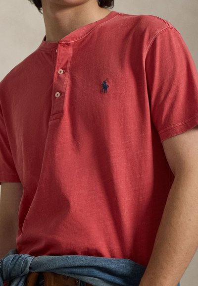 Κόκκινο βαμβακερό πουκάμισο henley με πατιλέτα τριών κουμπιών και λογότυπο σε ναυτικό μπλε. Μαλακή υφή με κοντά μανίκια και casual εφαρμογή.