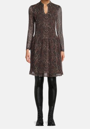 Vestido con estampado de piel de serpiente, de mangas largas y transparentes, con escote en forma de ojo de cerradura y falda acampanada. Medias opacas negras complementan las botas de tobillo.