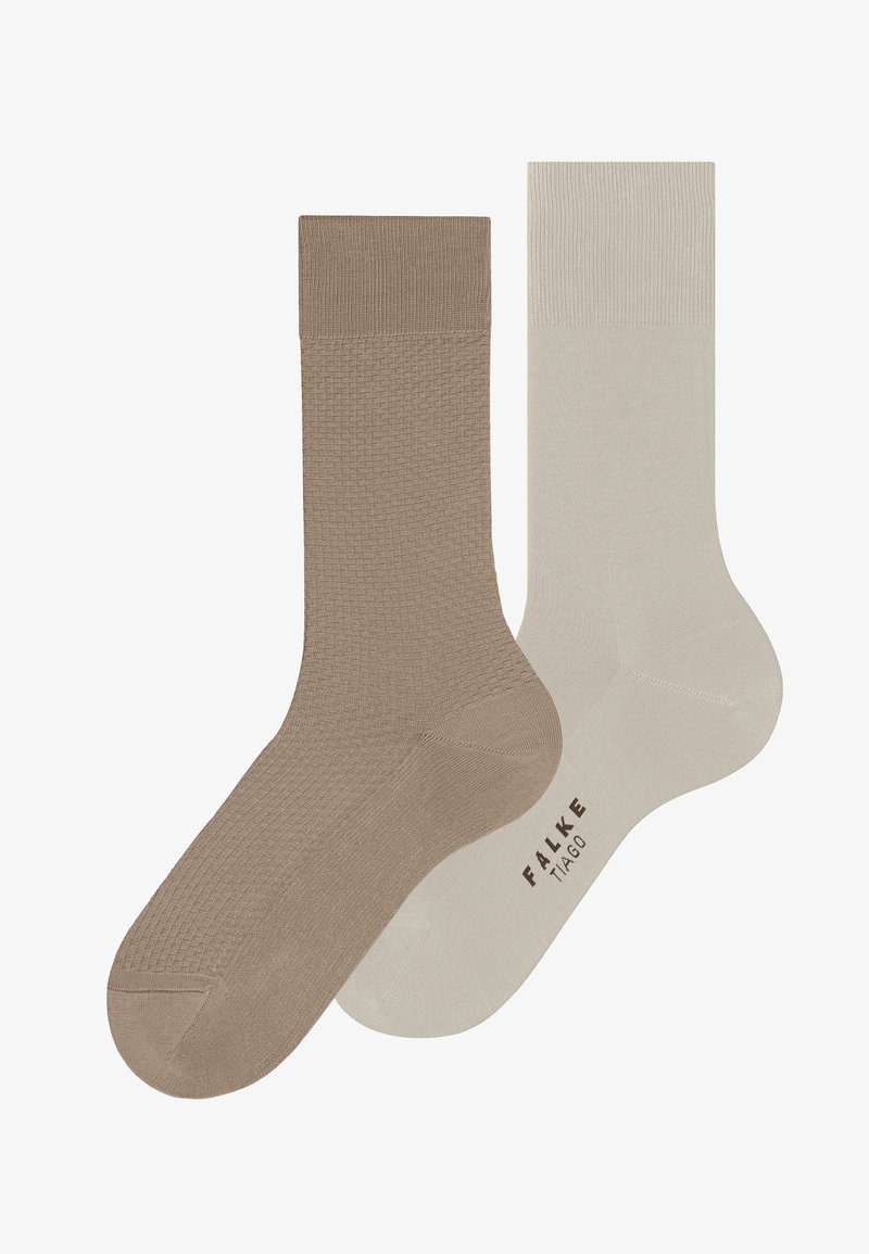 Δύο κάλτσες μήκους πληρώματος, μία με ανάγλυφη ανοιχτή καφέ απόχρωση και η άλλη σε λείο ανοιχτό γκρι με τη σήμανση "FALKE TIAGO" στη σόλα.