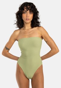 Maillot de bain une pièce sans bretelles de couleur verte avec texture côtelée, jambes hautes et design ajusté. Pas de matériel ni d'ornements visibles.