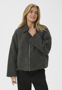 Graue, übergroße Jacke aus Wollmischung mit Reißverschluss vorne, Kragen und weiten Ärmeln. Verfügt über eine texturierte Oberfläche und seitliche Taschen.