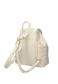 Sac à dos couleur crème avec un motif texturé tissé sur le côté. Dispose de deux bretelles réglables et d'une poignée supérieure. Accents de quincaillerie dorée.