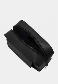 Black leather rectangular bag with zip closure, featuring a smooth texture and a simple design. Interior visible, showing a dark lining.