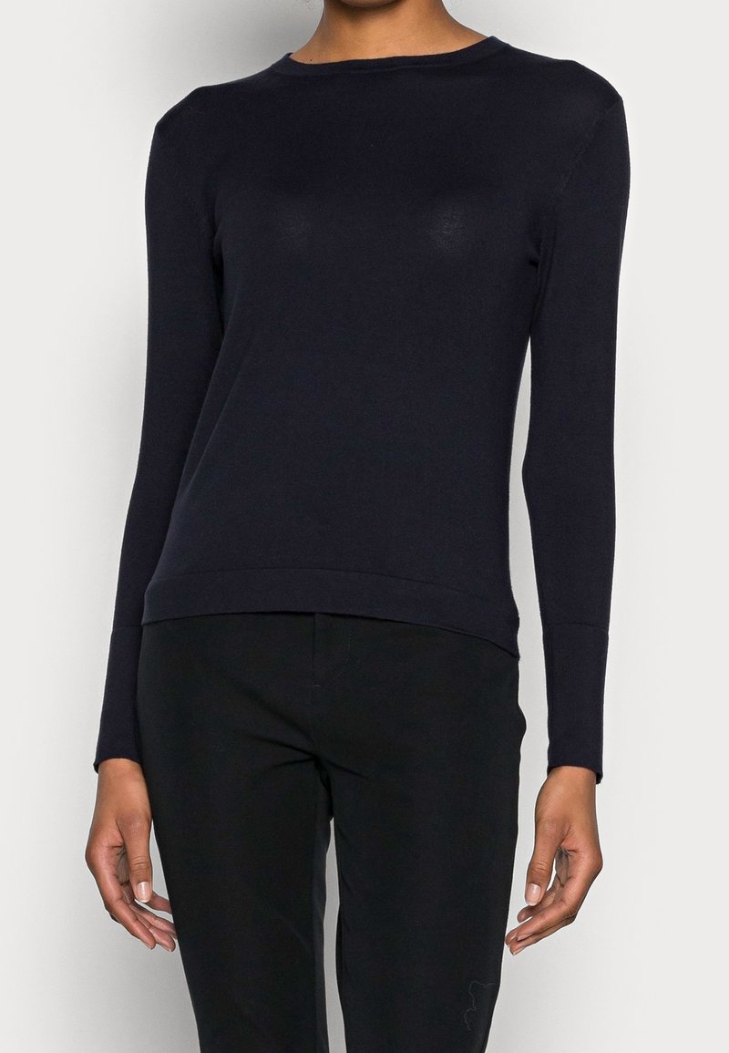Navyblaues Langarmoberteil aus weichem Stoff mit Rundhalsausschnitt, figurnahem Schnitt und leicht verkürztem Saum. Einfaches, nahtloses Design.