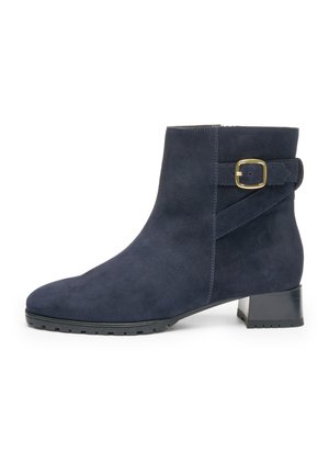 Marineblaue Wildleder-Stiefeletten mit seitlicher Schnallendetail, abgerundeter Spitze und kleinem Blockabsatz mit strukturiertem Profil für besseren Halt.