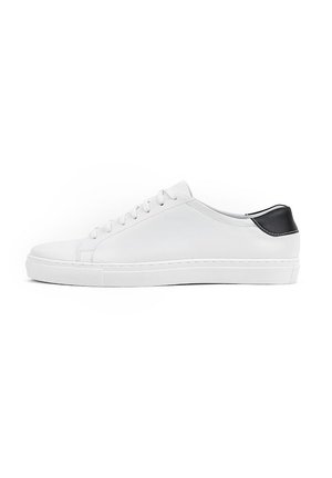 Białe skórzane sneakersy z płaską podeszwą, okrągłym noskiem i sześcioma oczkami do sznurowania. Czarny akcent na pięcie. Gładka tekstura z minimalnym zdobieniem.