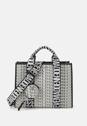 Sac fourre-tout Steve Madden noir et blanc avec motif de logo répétitif, large bandoulière brandée et pochette ronde pour pièces attachée.