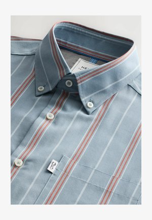 Light blue striped button-up shirt with red and white stripes, cotton fabric, pointed collar, chest pocket, and tag with logo.
