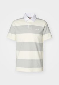 Polo à manches courtes avec de larges bandes horizontales grises et blanches et un col blanc, arborant un petit logo Levi's sur la poitrine.