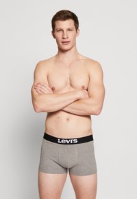 Harmaat puuvillaboksit tarjoavat mustan vyötärönauhan, jossa on valkoista "Levi's"-brändäystä. Istuvuus on tiukka ja vyötärönauha on keskikorkea.