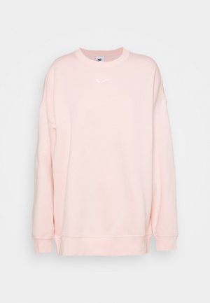 Sweat-shirt Nike rose clair à manches longues avec logo Nike swoosh blanc centré sous l'encolure sur un fond uni.