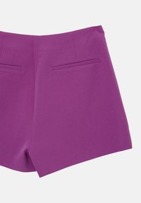 Shorts violets en tissu texturé, dotés de deux poches arrière et d'une coupe nette et ajustée avec des bords précis et un design global élégant.