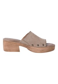 Mules à talons en suede beige avec un orteil ouvert, comportant une large sangle et trois clous décoratifs sur le côté. Talon en bois texturé.
